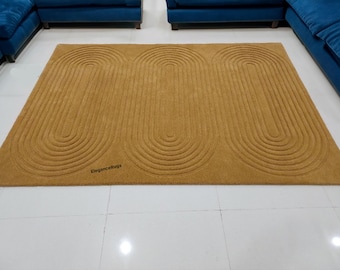 Può includere: Un tappeto giallo senape con un motivo geometrico di ovali concentrici. Il tappeto ha una texture morbida e soffice ed è perfetto per aggiungere un tocco di stile moderno a qualsiasi stanza.