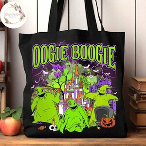 Puede incluir: Bolsa de tela negra con un gr&aacute;fico verde y morado de Oogie Boogie de Pesadilla antes de Navidad. El gr&aacute;fico incluye a Oogie Boogie, la Mansi&oacute;n Embrujada y las palabras "Oogie Boogie".