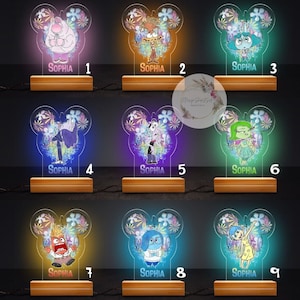 May include: Nine different light-up nightlight designs featuring characters from the movie Inside Out. Each design features a different character with a different colored background. The name "Sophia" is printed on each design. The designs are numbered 1 through 9.