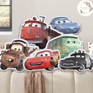 May include: A selection of die-cut car character decorations. The set features a red fire engine, a blue sports car, a green van, a brown tow truck, a red race car, and a black police car. The cars have cartoon features and are on a beige surface.