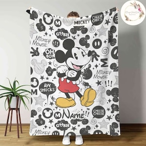Może przedstawiać: Czarno-biała kołdra z Mickey Mouse'em z wzorem bazgroł&oacute;w. Kołdra przedstawia Mickey Mouse'a w jego charakterystycznych czerwonych spodenkach i ż&oacute;łtych butach. Wz&oacute;r zawiera głowę Mickey Mouse'a, gwiazdki i słowa "Mickey Mouse", "Oh Boy", "Aw Shucks", "Gush", "Name" i "Cheese Cheese".