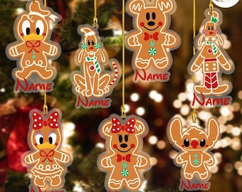 May include: Set of six gingerbread character ornaments with red and white accents. Each ornament features a different Disney character, including Mickey Mouse, Minnie Mouse, Stitch, Donald Duck, Pluto, and a gingerbread man. Each ornament has a clear plastic background with the word "Name" printed on it.