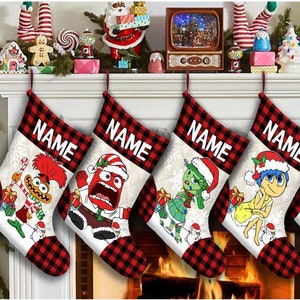 May include: Five red and black plaid Christmas stockings with different characters from the movie Inside Out. The stockings have the word "NAME" printed on them. The characters are Joy, Sadness, Anger, Disgust, and Fear.