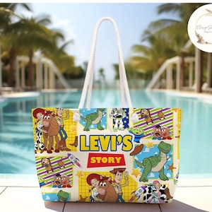 以下が含まれることがあります： おもちゃのストーリー映画フランチャイズのキャラクターが描かれたカラフルなデザインの白いトートバッグ。バッグには白いロープハンドルと、前面に「Levi's Story」という文字が印刷されています。