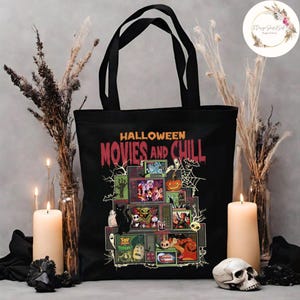 May include: Black tote bag featuring the text "Halloween Movies and Chill" with a graphic of stacked televisions displaying Halloween-themed movies. The bag has black handles and is surrounded by candles, dried plants, and a skull.