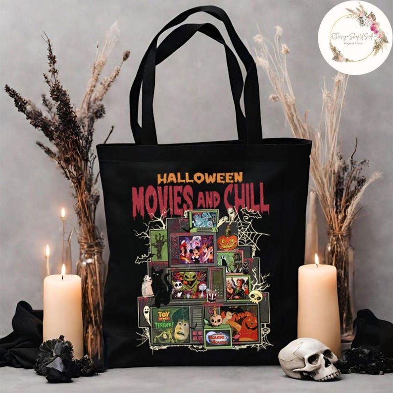 May include: Black tote bag featuring the text "Halloween Movies and Chill" with a graphic of stacked televisions displaying Halloween-themed movies. The bag has black handles and is surrounded by candles, dried plants, and a skull.