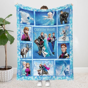May include: A blue and white fleece blanket with a patchwork design featuring characters from the movie Frozen. The blanket has images of Elsa, Anna, Kristoff, Olaf, Sven, and the snow monster. The text "CUSTOM NAME" is printed in the center of the blanket.