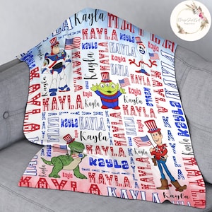 Puede incluir: Una manta de beb&eacute; blanca con un tema patri&oacute;tico rojo, blanco y azul. La manta presenta el nombre "Kayla" repetido en todo el dise&ntilde;o, junto con im&aacute;genes de personajes de Toy Story con sombreros patri&oacute;ticos.