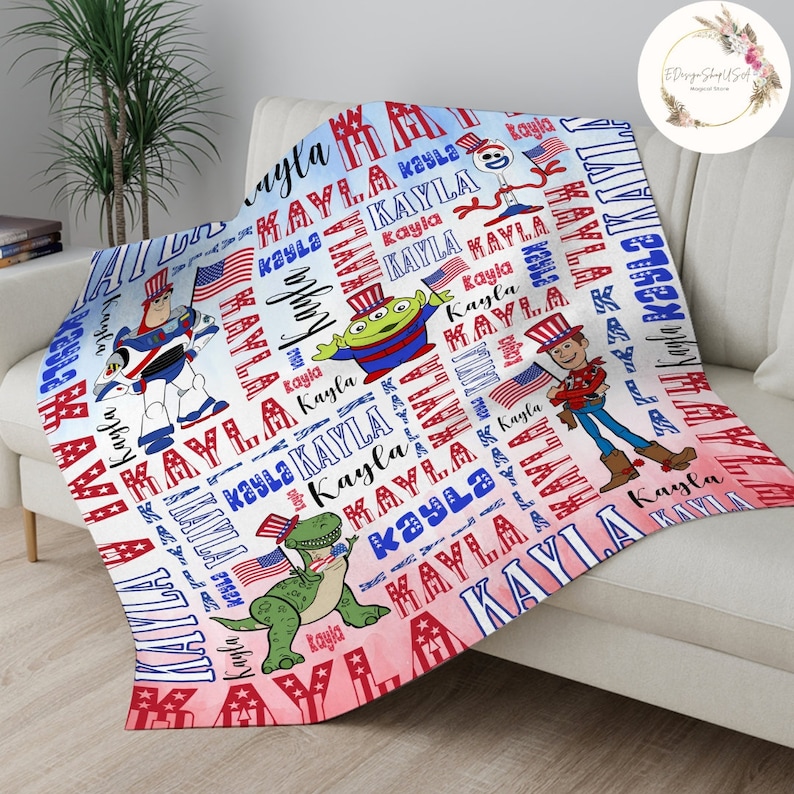 Puede incluir: Una manta roja, blanca y azul con un fondo de acuarela. La manta presenta un patr&oacute;n repetido del nombre "Kayla" e im&aacute;genes de personajes de Toy Story, incluidos Woody, Buzz Lightyear, Rex y el extraterrestre.