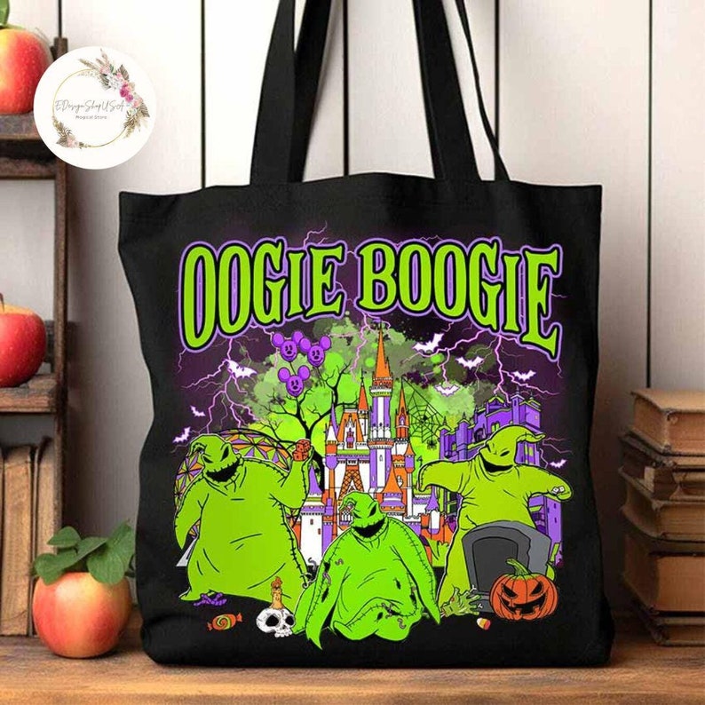 Puede incluir: Bolsa de tela negra con un gr&aacute;fico verde y morado de Oogie Boogie de Pesadilla antes de Navidad. El gr&aacute;fico incluye a Oogie Boogie, la Mansi&oacute;n Embrujada y las palabras "Oogie Boogie".