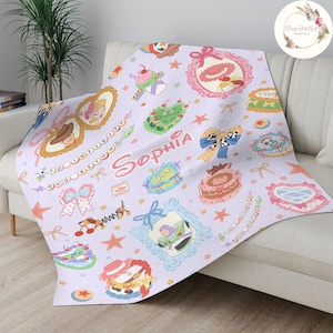 May include: A purple, pink, and blue personalized blanket with a Toy Story theme. The blanket features characters like Woody, Buzz Lightyear, and Jessie. The blanket is decorated with stars, hearts, and other fun designs. The name "Sophia" is written in a whimsical font on the blanket.