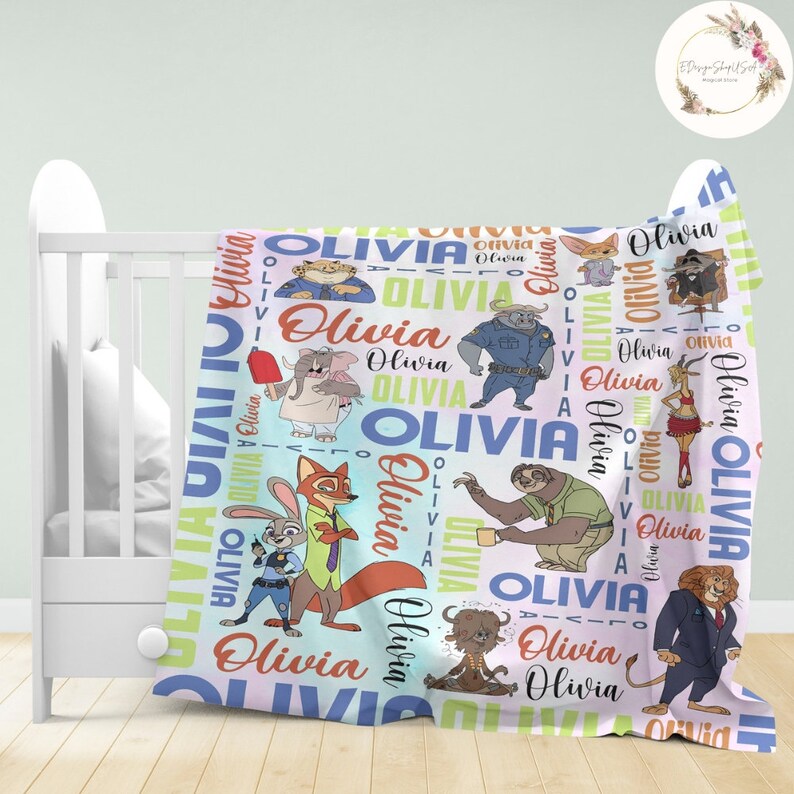 Pu&ograve; includere: Una copertina per neonati rosa e blu con un motivo colorato di animali dei cartoni animati e il nome "Olivia" ripetuto ovunque.