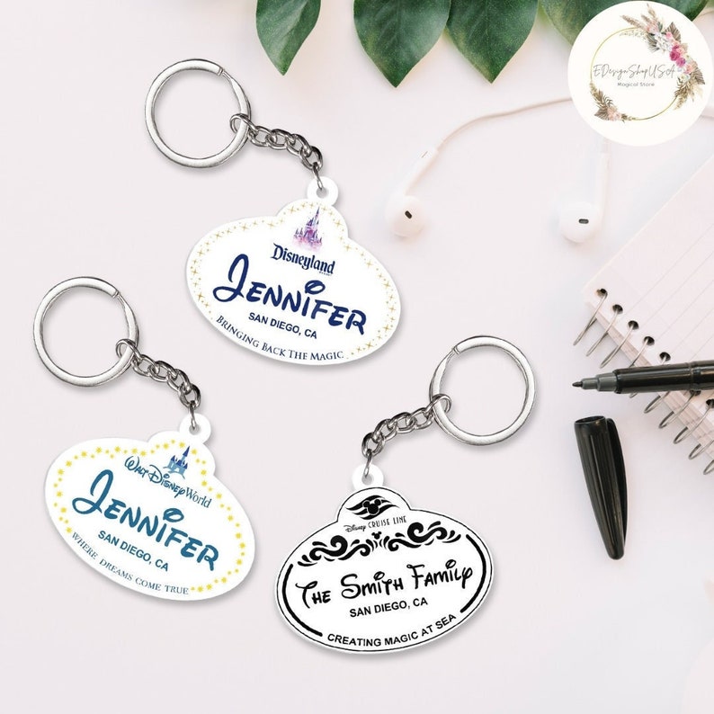 May include: Three white plastic keychains with black text and images. The first keychain has a Disneyland logo and says "Jennifer, San Diego, CA, Bringing Back The Magic". The second keychain has a Walt Disney World logo and says "Jennifer, San Diego, CA, Where Dreams Come True". The third keychain has a Disney Cruise Line logo and says "The Smith Family, San Diego, CA, Creating Magic At Sea".