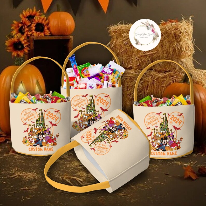 May include: Three Halloween treat bags with a Mickey Mouse theme. The bags are beige with a yellow handle and feature a print of Mickey Mouse and friends in front of Cinderella's Castle. The bags are filled with candy and have the text "Mickey's Halloween Party 2024" printed on them.