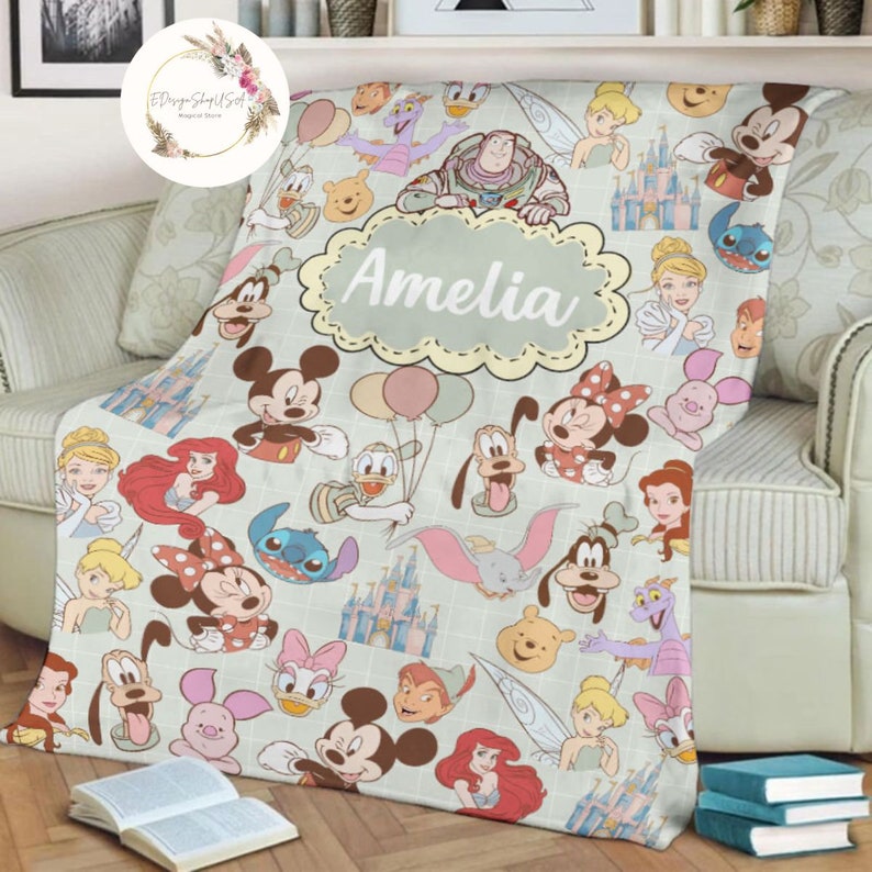 May include: A personalized Disney character themed fleece blanket with the name Amelia in a decorative circle. The blanket features a variety of Disney characters including Mickey Mouse, Minnie Mouse, Donald Duck, Goofy, Pluto, and more.
