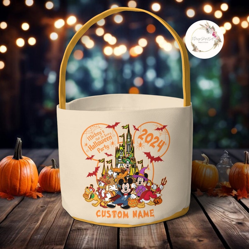 May include: A white canvas trick-or-treat bag with a yellow handle. The bag features a Mickey Mouse head silhouette with a  castle and Mickey Mouse characters inside. The text on the bag reads "Mickey's Not-So-Scary Halloween Party 2024" and "CUSTOM NAME".
