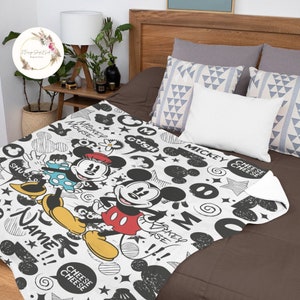 Może przedstawiać: Biały koc z polaru z czarno-białym wzorem bazgroł&oacute;w przedstawiającym Myszki Miki i Minnie. Koc ma napisane na nim słowa "Mickey Mouse", "Gosh", "Mickey", "Cheese Cheese", "Shucks", "Name" i "Take You Home".