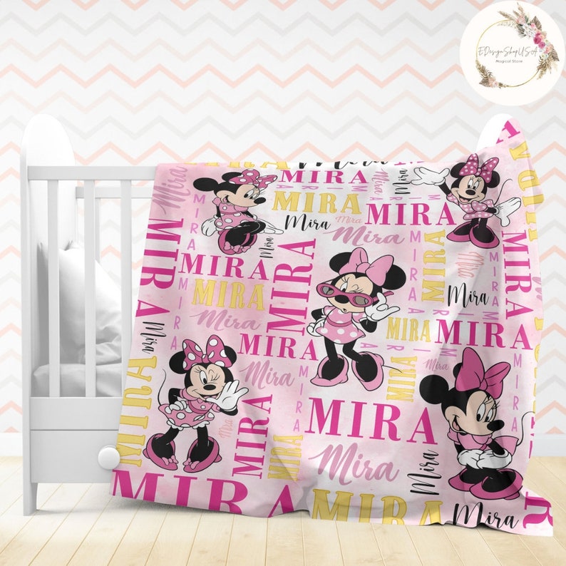 Puede incluir: Manta personalizada rosa y amarilla con tem&aacute;tica de Minnie Mouse. La manta presenta un patr&oacute;n repetido del nombre "Mira" e im&aacute;genes de Minnie Mouse en diferentes poses.