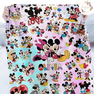 May include: A white and pink blanket with a repeating pattern of Mickey Mouse and Minnie Mouse in various poses. The blanket features the word "LOVE" and the name "Olivia".