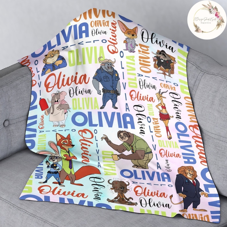 Pu&ograve; includere: Una copertina per neonati bianca e rosa con un motivo colorato di animali dei cartoni animati e il nome "Olivia" ripetuto ovunque.