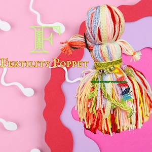 May include: A colorful yarn doll with a long, flowing skirt made of yarn. The doll is decorated with green leaves and a gold ribbon. The doll is on a pink and white background with the text "FERTILITY POPPET" and the letter "F" in green.