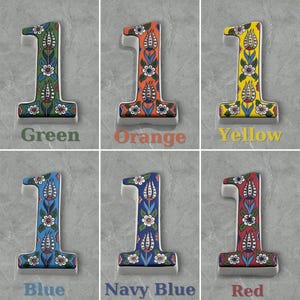 May include: Six ceramic house numbers, each featuring the number "1" in a white background with a colorful floral design. The numbers are displayed in six different colors: green, orange, yellow, blue, navy blue, and red.