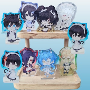 May include: A selection of anime-style acrylic standees depicting characters in maid outfits with cat ears. The standees are presented on a wooden shelf, against a light blue backdrop. Each character has distinct hair and eye colours.