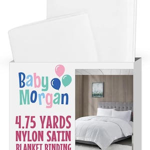 May include: White baby blanket with a box featuring the text "Baby Morgan" and "4.75 YARDS NYLON SATIN BLANKET BINDING". The box also includes an image of a white bed set. The blanket is pre-folded and ready to use.