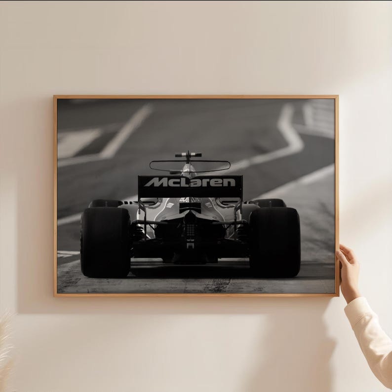 Puede incluir: Fotograf&iacute;a en blanco y negro de un coche de carreras de F&oacute;rmula 1 McLaren en una pista. El coche est&aacute; de frente a la c&aacute;mara y el logotipo de McLaren es visible en el aler&oacute;n trasero.