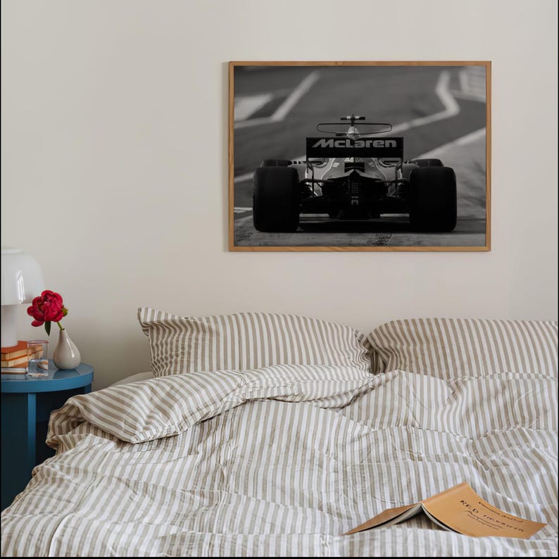 Puede incluir: Foto en blanco y negro de un coche de carreras de F&oacute;rmula 1 McLaren en una pista. El coche est&aacute; enfocado y el fondo est&aacute; desenfocado.