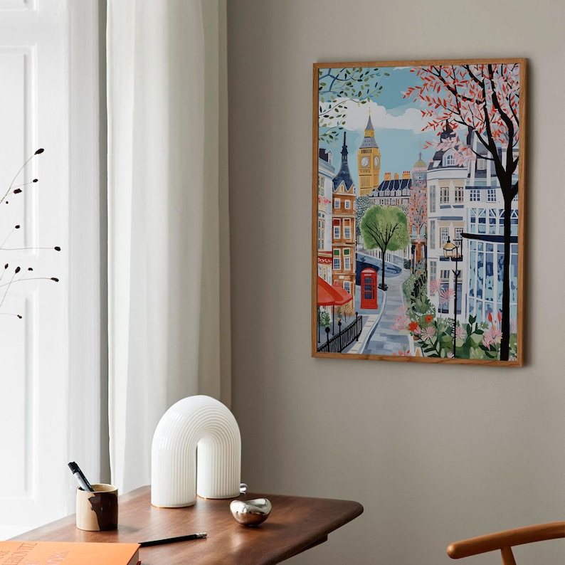 May include: A colorful illustration of a street scene in London, England. The image features Big Ben, a red telephone booth, and a cafe with a red awning. The street is lined with buildings and trees.