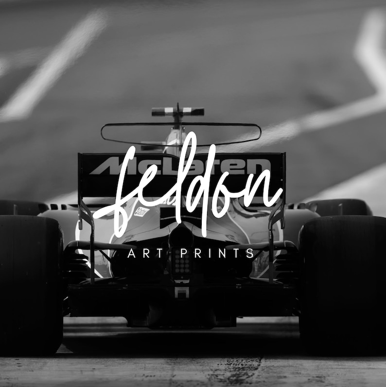 Puede incluir: Foto en blanco y negro de un coche de carreras de F&oacute;rmula 1 con el texto "feldon ART PRINTS" en el lateral.