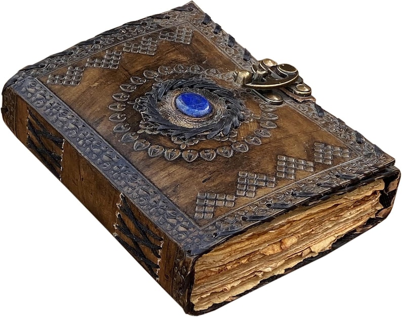 May include: A handcrafted, antique-style journal with a brown leather cover. The cover features intricate embossed patterns, a blue gemstone, and a decorative metal clasp. The pages have a vintage, aged appearance.