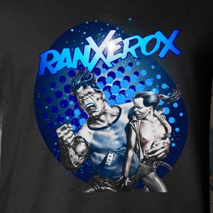 May include: A black short-sleeved t-shirt featuring a graphic print of the comic book character RanXerox. The design includes the blue text RANXEROX above a central illustration of a muscular figure and a smaller companion against a blue dotted circle.