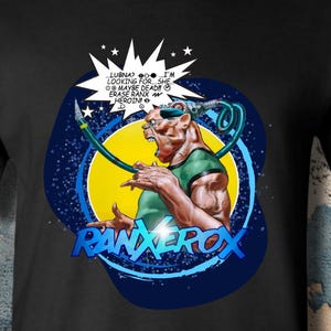 May include: A black short-sleeve t-shirt featuring a graphic print of the character Ranxerox. The design includes a yellow circle, a blue background, and a speech bubble with text that reads: LUBNA? I'M LOOKING FOR... SHE MAYBE DEAD!! ERASE RANX HEROIN.