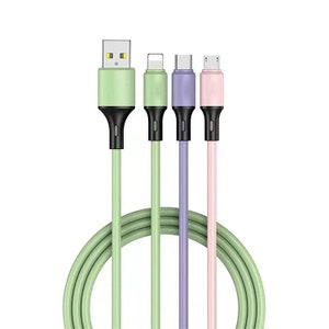 Puede incluir: Un cable de carga multicolor con cuatro tipos de conectores diferentes: USB, Lightning, USB-C y Micro-USB. El cable presenta una combinación de colores verde, verde claro, morado y rosa. El cable está enrollado en la parte inferior.