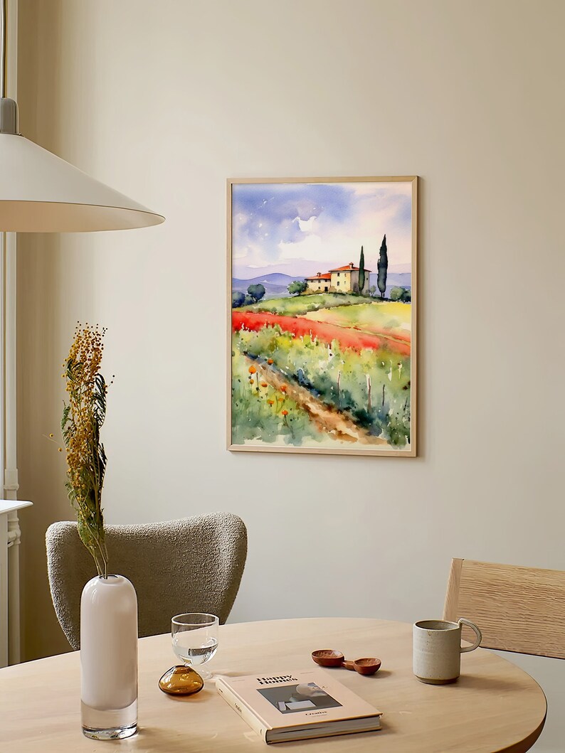 May include: A watercolor painting of a house in a field with a path leading to it. The house is yellow with a red roof and there are two tall trees in the background. The field is green with red flowers and the sky is blue with white clouds.