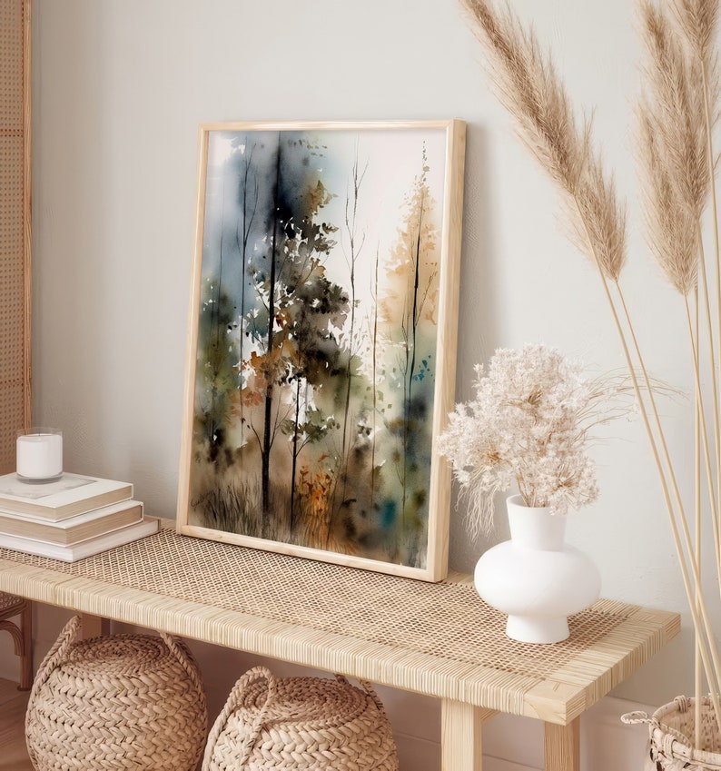 May include: A framed watercolor painting of a forest scene with trees in shades of brown, green, and blue. The painting is hanging on a wall above a wooden bench with woven cushions.