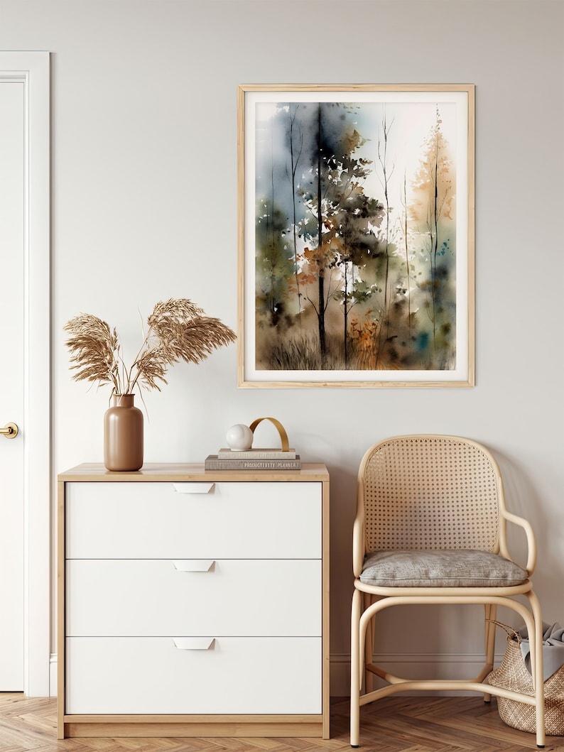 May include: A watercolor painting of a forest scene with tall trees in shades of brown, green, and blue. The painting is framed in a light wood frame and hangs on a white wall.