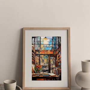 May include: A framed watercolour painting of a bookstore interior with a large window, bookshelves, and a table with books on it. The painting is in a light wood frame and is hanging on a white wall.