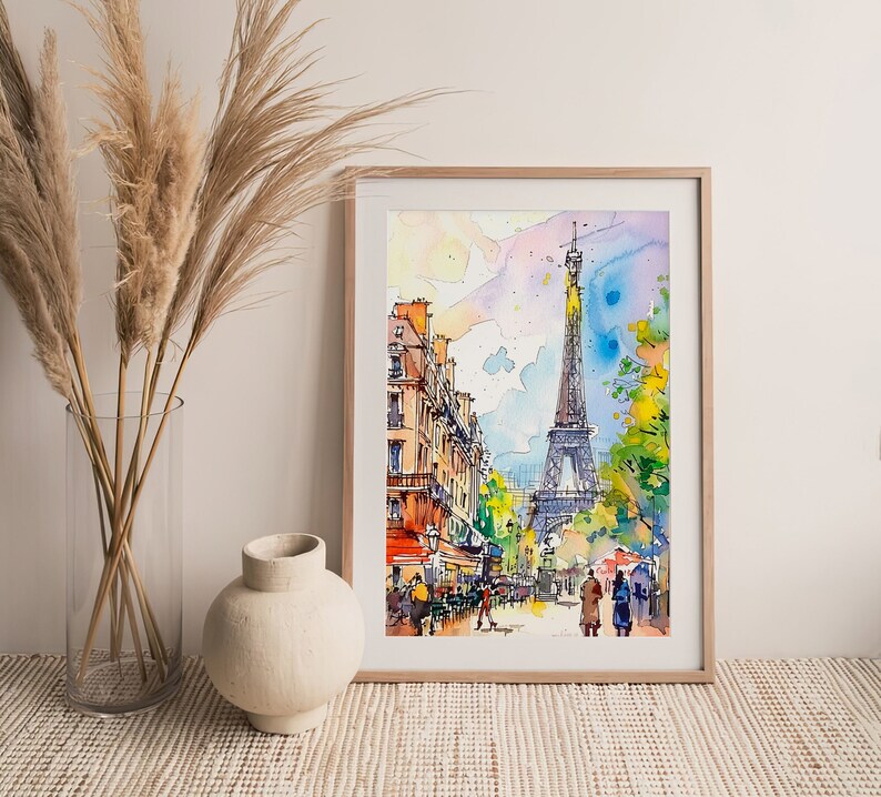 Puede incluir: Una pintura de acuarela de la Torre Eiffel en Par&iacute;s, Francia. La pintura representa una escena de calle con edificios y personas caminando. La pintura est&aacute; enmarcada en un marco de madera claro.