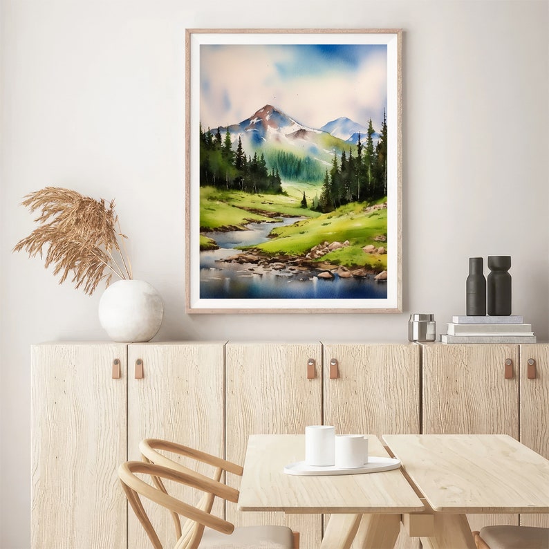 May include: A watercolour painting depicting a mountainous landscape with a river winding through a valley. The mountains are covered in green trees and the sky is a light blue with white clouds.