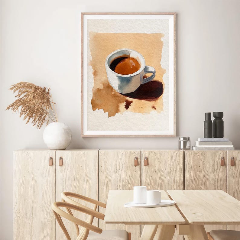 Puede incluir: Una pintura de acuarela enmarcada de una taza de caf&eacute; blanca con un l&iacute;quido marr&oacute;n en su interior, sentada sobre una superficie marr&oacute;n claro. La taza proyecta una sombra sobre la superficie.