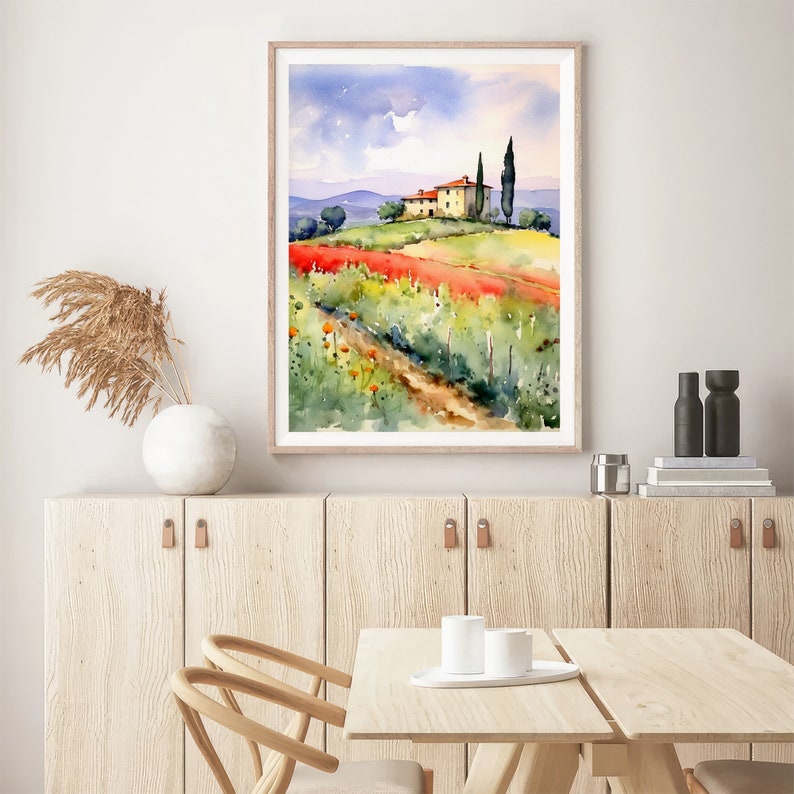 May include: Watercolor painting of a yellow house with a red tile roof on a green hill with a dirt path leading to the house. The house is surrounded by green trees and red flowers. The sky is blue with white clouds.