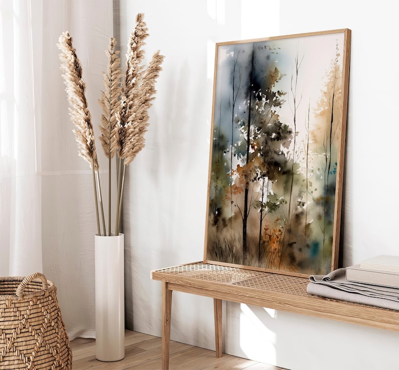 May include: A framed watercolor painting of a forest scene with tall trees in shades of brown, green, and blue. The painting has a soft, dreamy feel and is perfect for adding a touch of nature to any room.