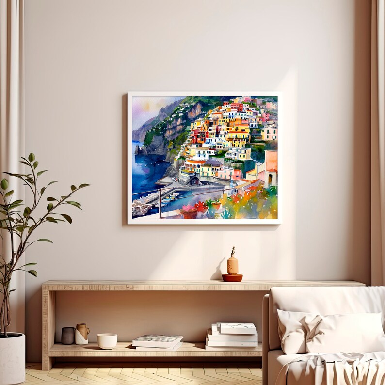 May include: Watercolour painting of a colourful Italian village built on a cliffside overlooking the ocean. The houses are painted in shades of yellow, orange, red, and green. The ocean is a deep blue, and the sky is a light blue.