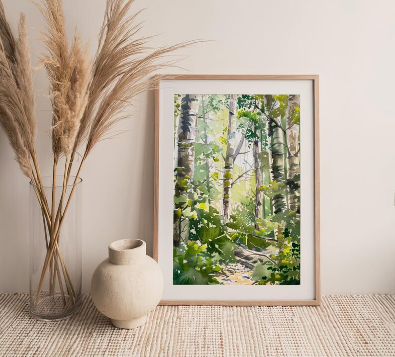 May include: A framed watercolor painting of a forest scene with tall trees and green foliage. The painting is in a light wood frame and is hanging on a white wall.