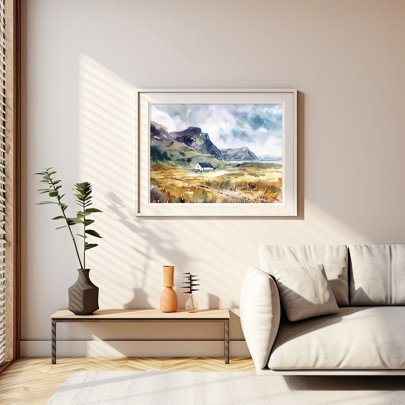 Pu&ograve; includere: Un dipinto ad acquerello incorniciato di un paesaggio con una piccola casa bianca in lontananza. Il dipinto presenta una catena montuosa, un specchio d'acqua e un campo d'erba in tonalit&agrave; di verde, marrone e giallo. Il cielo &egrave; azzurro chiaro con nuvole bianche.