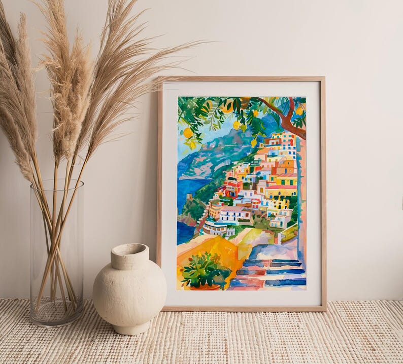 May include: Watercolour painting of a coastal Italian village with colourful buildings cascading down a hillside. The artwork features a vibrant palette of blues, yellows, oranges, and greens, with a tree in the upper right corner.