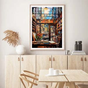 May include: A watercolour painting of a bookstore interior with a large window, wooden shelves filled with books, and a table with books on it. The painting is framed in a light wood frame.